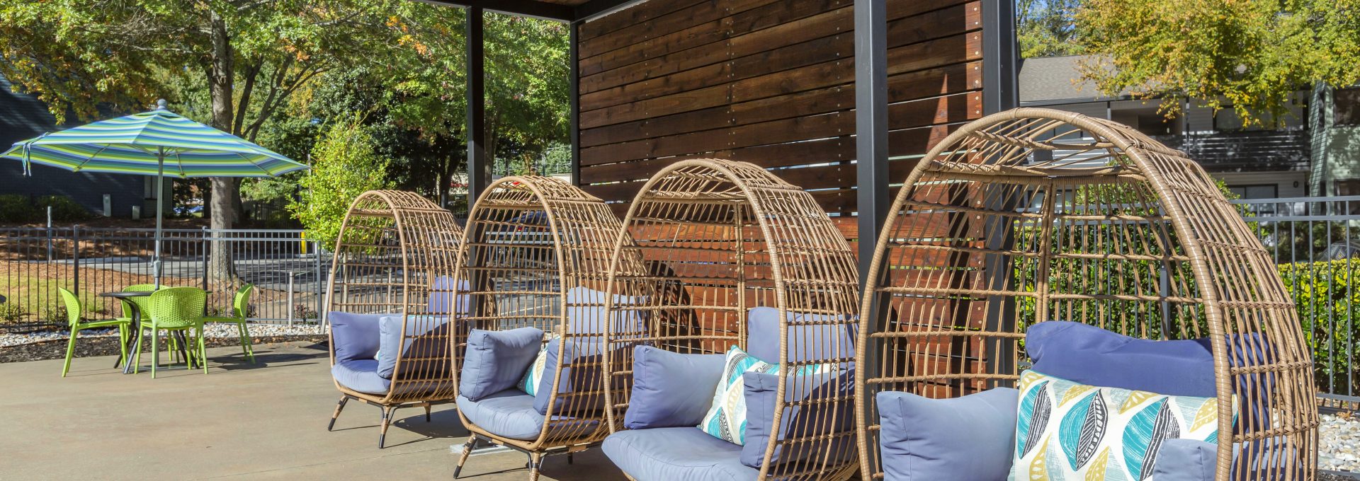 a patio with wicker chairs and umbrellas at The Terra at Norcross